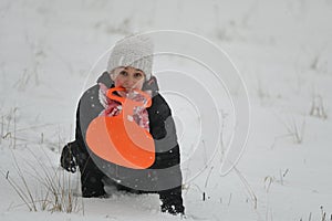 An entertaining child quadrupeds across a snowy meadow during a white winter's day