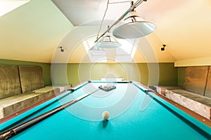 Entertainment attic room with a billiard table