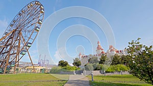 entertainment park. Action. A huge amusement park filmed in the summer. Ferris wheel.