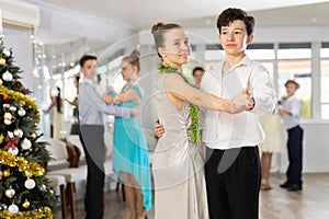 Enthusiastic adolescent dancers practicing partner dance in Christmas studio