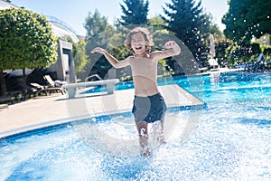 Enthusiastic boy running in the outdoor pool