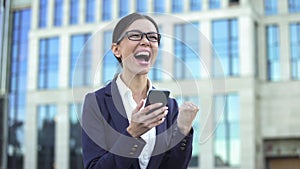 Enthusiastic business woman showing success gesture reading mobile email, career