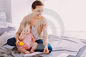 Enthusiastic businesswoman having a productive day while staying with a baby