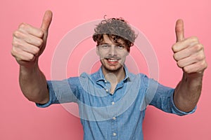 Enthusiastic casual young model making thumbs up sign