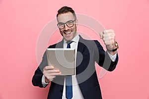 Enthusiastic elegant guy reading emails and celebrating victory