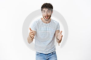 Enthusiastic and excited attractive young male model with blue eyes and bristle explaining something with thrilled