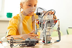 Enthusiastic girl building a robot during her science lesson.