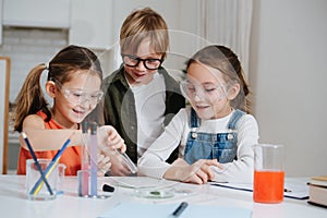 Enthusiastic little kids doing home science project, having fun