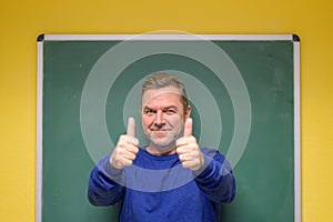 Enthusiastic male teacher giving double thumbs up