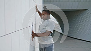 Enthusiastic man dancing wall rhythmically. Expressive guy creating techniques photo