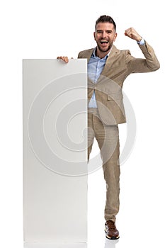 Enthusiastic man in his 40s holding and presenting board and celebrating