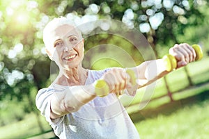 Enthusiastic pensioner being satisfied with little hand weights