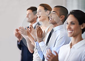 An enthusiastic round of applause. a row of businesspeople clapping.