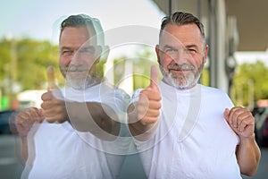 Enthusiastic smiling senior man giving a thumbs up of success