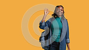 Enthusiastic student raising hand up to answer question, studio background