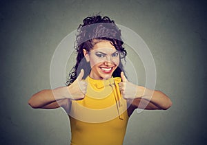 Enthusiastic woman giving thumbs up gesture of approval and success