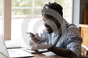 Enthusiastic young african male freelancer make good progress in multitask