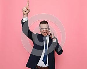 Enthusiastic young guy talking on the phone and smiling