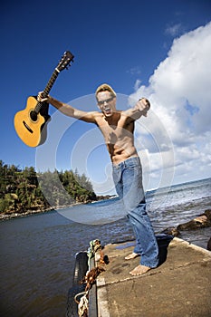 Enthusiastic Young Man With Guitar Standing Lakesi