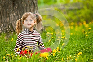 Enthusiastically surprised lovely little girl sitting in grass