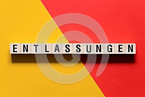 Entlassungen - layoffs in German word concept on cubes