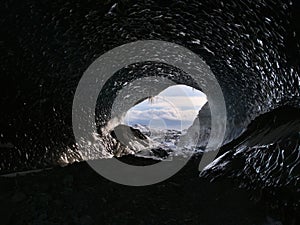 Entrance of the big Sapphire Ice Cave, located in BreiÃ°amerkurjÃ¶kull glacier, Iceland, viewed from inside with icicles.