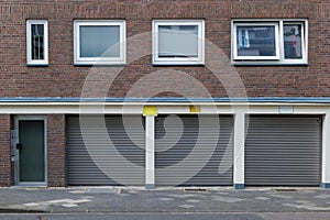 entrance of the building and shutter doors of garages under typical design of housing or apartment in Europe.