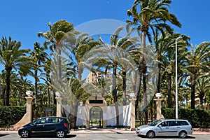 Entrance closed fenced doorway to the residential closed urbanization with palm lined lush trees, on the former site of mental