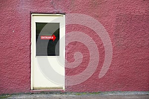 Entrance direction sign on yellow door and red background wall