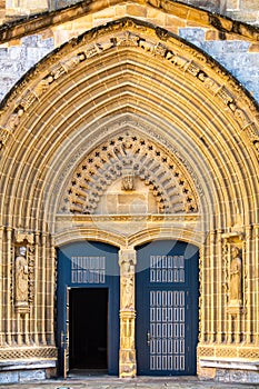 Entrance door and main facade of old stone church of Andra Maria in Guernica, Spain. Archway to medieval cathedral.