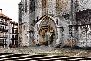 Entrance door and main facade of old stone church in Guernica, Basque Country, Spain. Romanesque architecture concept.