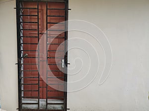 An entrance door secured with iron grill.