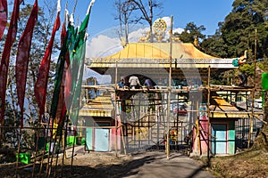 Entrance gate with construction area and colorful Tibetan flags of Guru Rinpoche Temple at Namchi. SIkkim, India