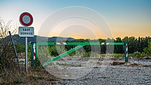 Entrance gate to the factory with a no-entry sign during sunset and mountain views