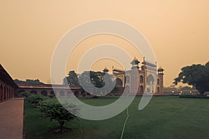 Entrance gate to the Taj Mahal before sunrise in misty day