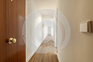 Entrance hall with an armored door of an empty house with a long corridor leading to multiple rooms