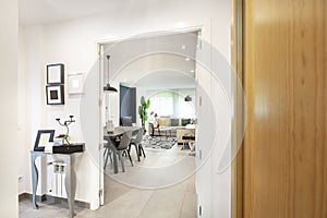 Entrance hall and living room with light stoneware floors, white carpentry,