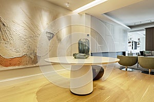 Entrance hall of a luxury house with a round table with vases, lattice