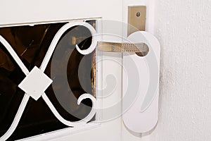 Entrance home with white door hanger of hotel room with empty sign please do not disturb