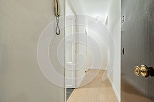 Entrance of a house with a dark wooden door, a light oak wooden floor