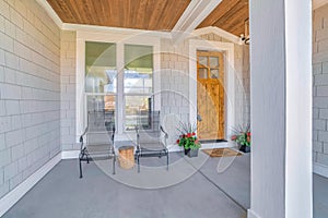 Entrance of a house with wooden front door with glass panes and potted plants