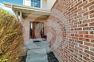 Entrance of a house with wooden front door and red bricks