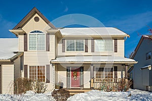 Entrance of luxury house with front yard in snow