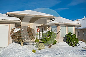 Entrance of luxury house with front yard in snow