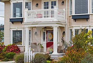 Entrance of a luxury house with a patio and beautiful landscaping on a sunny day. Home exterior