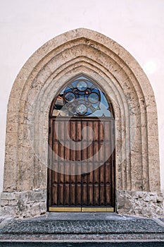 Entrance oak doors of Church. Masonry walls and mosaic window