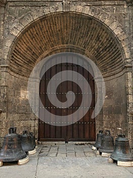 Entrance in old cuban temple, high wooden doors in the recess an