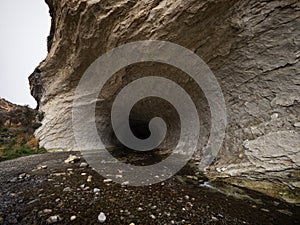 Entrance opening hole of dark black natural water tunnel at Broken River Cave Stream Reserve, Canterbury, New Zealand