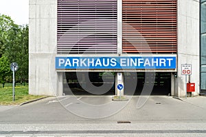 Entrance of a parking garage with the writen sign `Parkahsu Einfahrt` which means Parking garage entrance