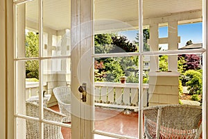 Entrance porch with wicker chair and glass door